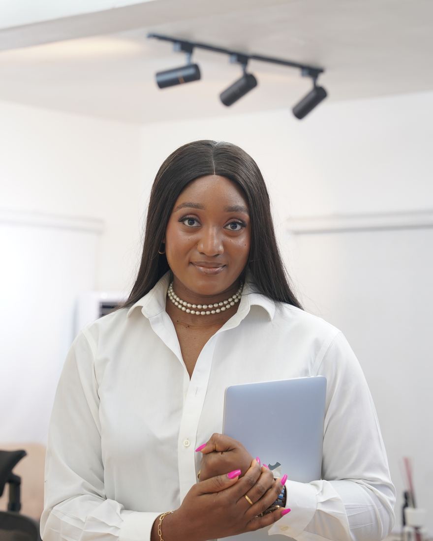 Nancy-Olive Tamuno in a white shirt holding a laptop